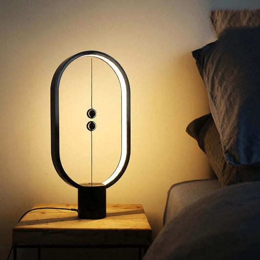 Magnetic Ornament LED lamp with oval frame on nightstand, featuring innovative magnetic switch and warm lighting.