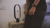 Person interacting with a modern Magnetic Ornament LED lamp on a bedside table in a stylish room.