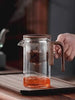 Elegant glass teapot with wooden handle, brewing tea with innovative infuser technology for perfect flavor.